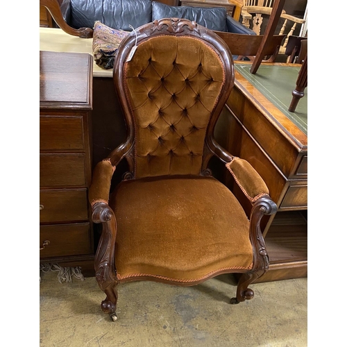 1045 - A Victorian walnut upholstered spoon back armchair