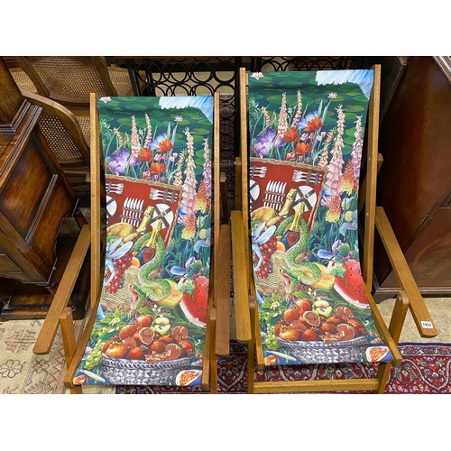 1053 - A pair of modern teak framed deck chairs with printed fabric panels