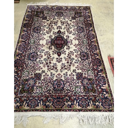 1068 - A Persian style red and cream ground wool rug, 207x 130cm