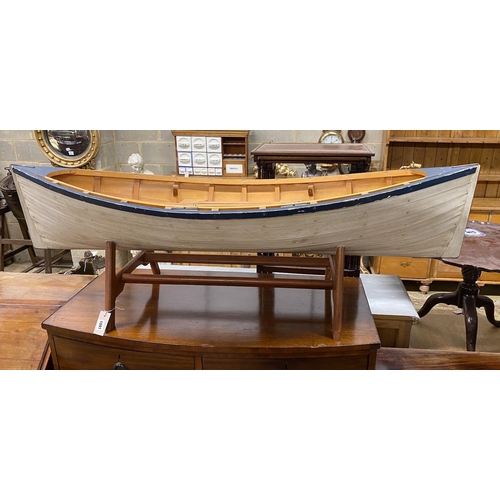 1091 - A model clinker built rowing boat with oars and stand, length 150cm