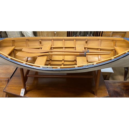 1091 - A model clinker built rowing boat with oars and stand, length 150cm