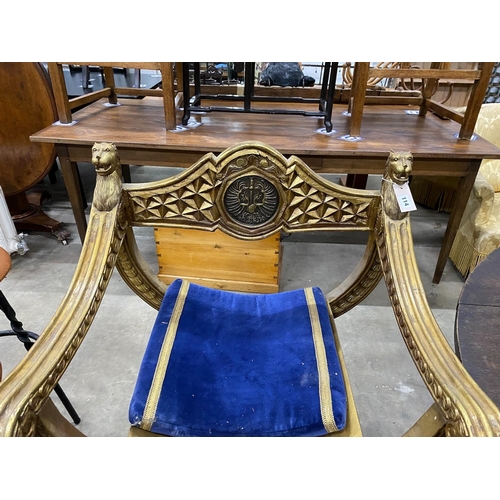 114 - A classical style gilt x-frame elbow chair, width 73cm, depth 52cm, height 96cm and a matching foots... 