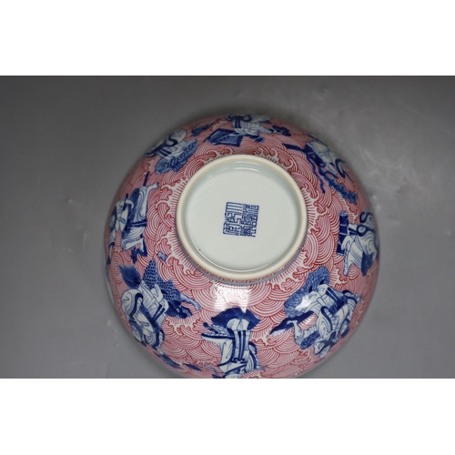 252 - A Chinese underglaze blue and puce enamelled 'eight immortals' bowl, 22cm diameter