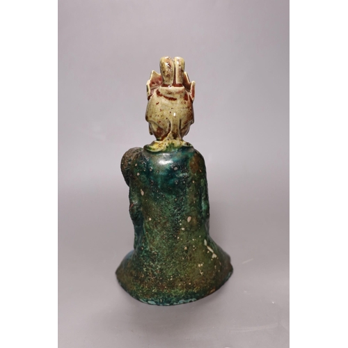 255 - A 19th century Chinese flambé glazed seated figure of an immortal, 25cm