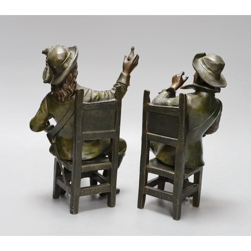 355 - A pair of early 20th century patinated bronzed metal figures of seated cavaliers, 25 cms high,... 