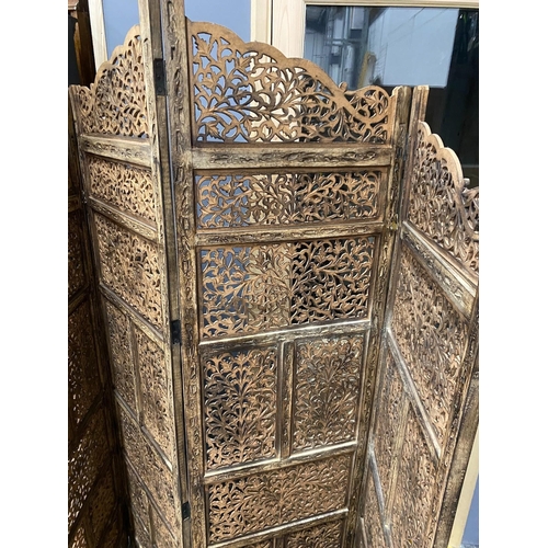 4 - An Indian carved hardwood four fold screen, largest panel width 50cm, height 184cm