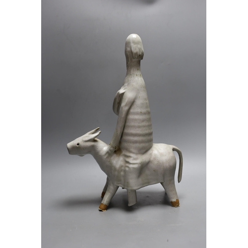 444 - An abstract studio pottery figure of man on a donkey. 43cm high