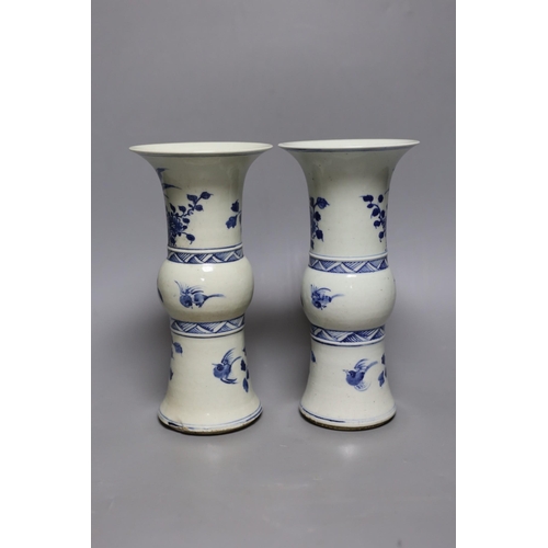 502 - A pair of 19th century Chinese blue and white beaker vases, 23.5cm