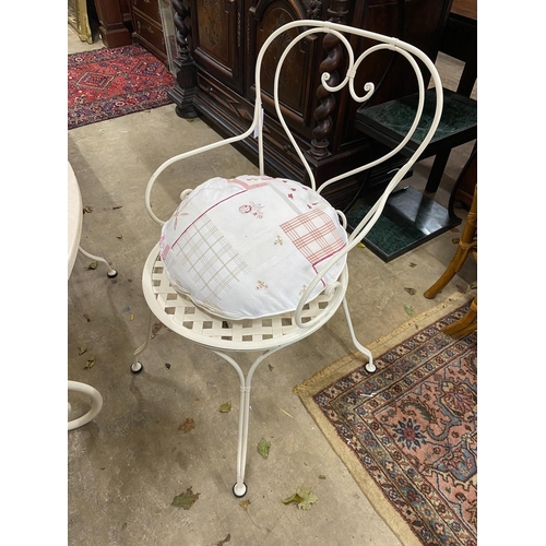 52 - A circular reconstituted marble garden table, diameter 120cm, height 74cm and four painted wrought i... 