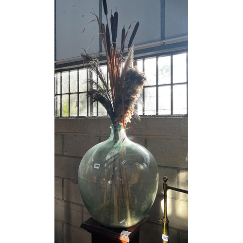 1027 - An early 20th century oak pedestal and a green glass carboy, combined height 150cm