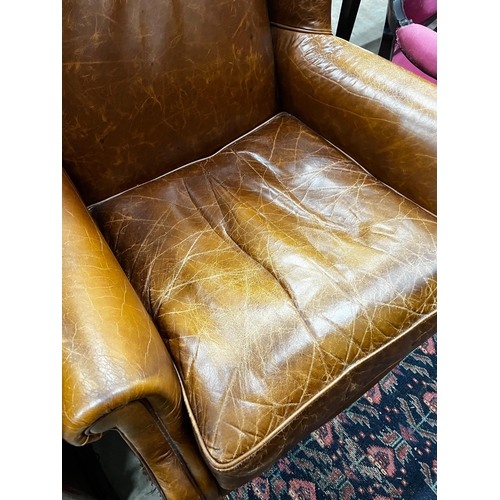 1053 - A Victorian style tan leather upholstered wingback armchair, width 78cm, depth 84cm, height 100cm... 