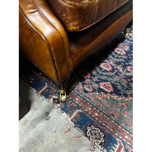 1053 - A Victorian style tan leather upholstered wingback armchair, width 78cm, depth 84cm, height 100cm... 