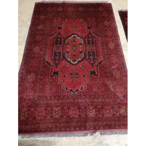 1009 - An Afghan red ground rug, 200 x 130cm