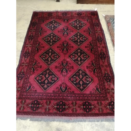 1010 - An Afghan red ground rug, 190 x 128cm