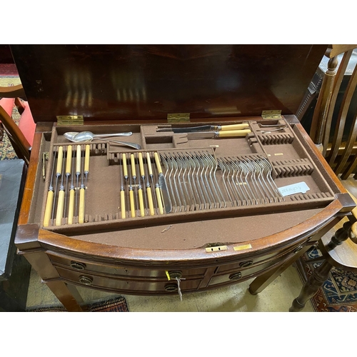 1100 - An early 20th century matched silver plated part canteen, in mahogany bow front four drawer table ca... 