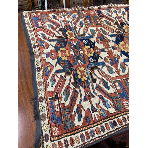 1195 - An antique Caucasian ivory ground Karabagh triple medallion rug, 224 x 130cm