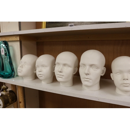 1261 - A set of seven fibreglass mannequin heads, largest 23cms high