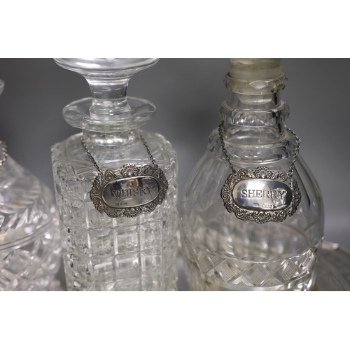 1320 - A silver plated oval tray, five assorted cut glass decanters and five assorted silver wine labels.... 