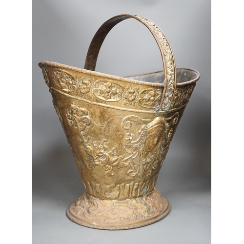 1356 - An embossed brass helmet coal bucket, 48cms high