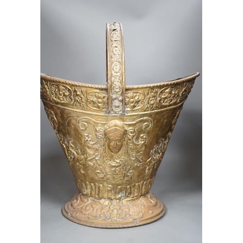 1356 - An embossed brass helmet coal bucket, 48cms high