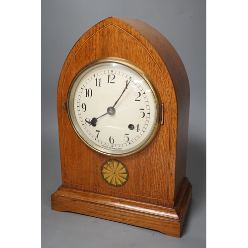 1365 - A pair of ebony rhinoceros book ends, together with an Edwardian oak lancet mantel clock, 35cm high... 