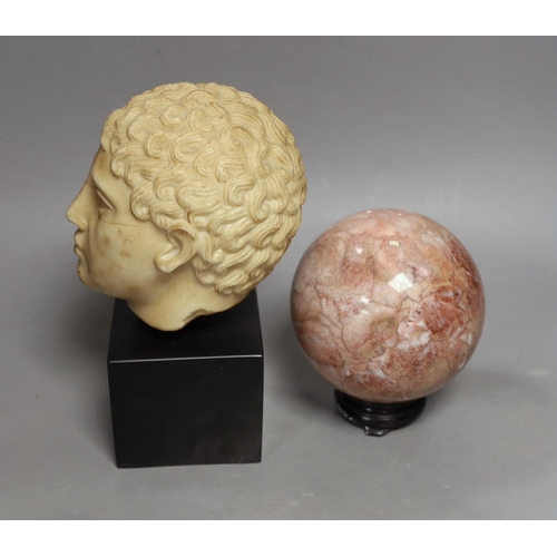 1424 - A simulated marble Roman head ornament, 24 cm and a rouge marble ball on stand, 15 cm