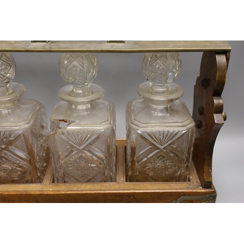 1569 - A Victorian Betjemanns patent oak cased three bottle tantalus (a.f.)