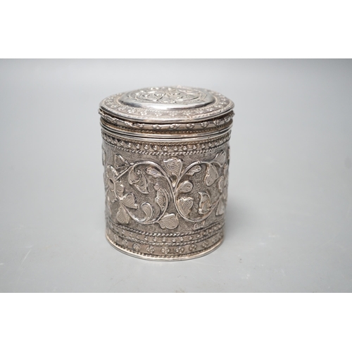 1803 - An Indian embossed white metal cigar case, 12.2cm and a similar canister and cover.