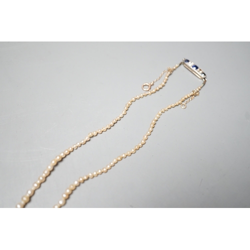 1878 - A single strand graduated natural saltwater pearl necklace, with sapphire and diamond set clasp, 44c... 