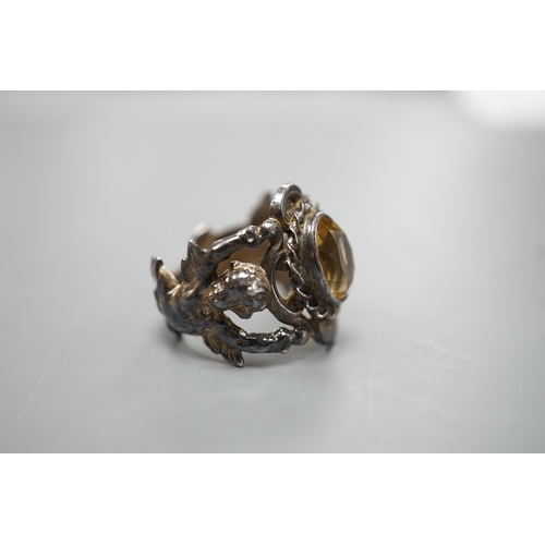 1880 - A 1960's silver and oval cut citrine set ring, the shank modelled and twin cupids, size O, gross wei... 