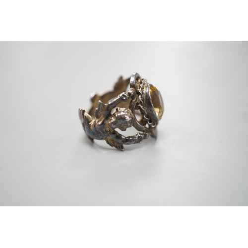 1880 - A 1960's silver and oval cut citrine set ring, the shank modelled and twin cupids, size O, gross wei... 