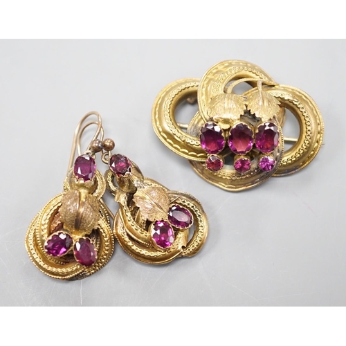 1888 - A Victorian yellow metal, oval and round cut garnet set demi parure, comprising a scroll work brooch... 