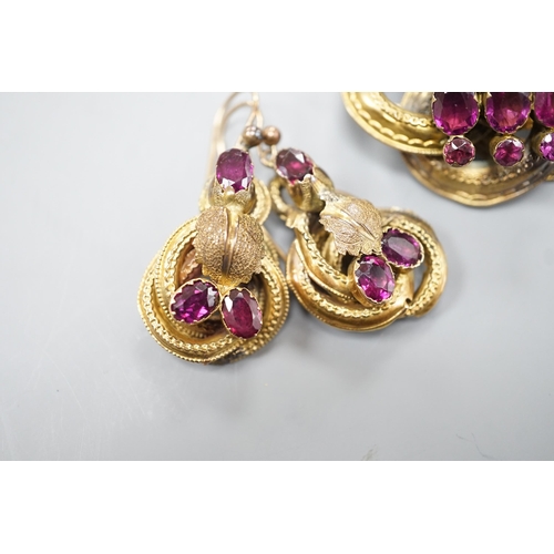 1888 - A Victorian yellow metal, oval and round cut garnet set demi parure, comprising a scroll work brooch... 