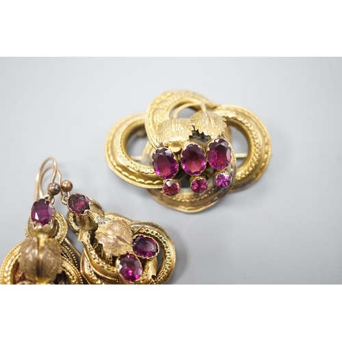 1888 - A Victorian yellow metal, oval and round cut garnet set demi parure, comprising a scroll work brooch... 