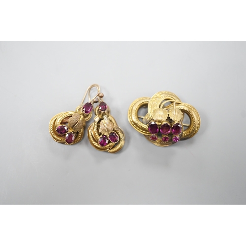 1888 - A Victorian yellow metal, oval and round cut garnet set demi parure, comprising a scroll work brooch... 