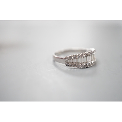 1916 - A modern white metal, graduated baguette cut diamond set half hoop ring, with diamond chip borders, ... 