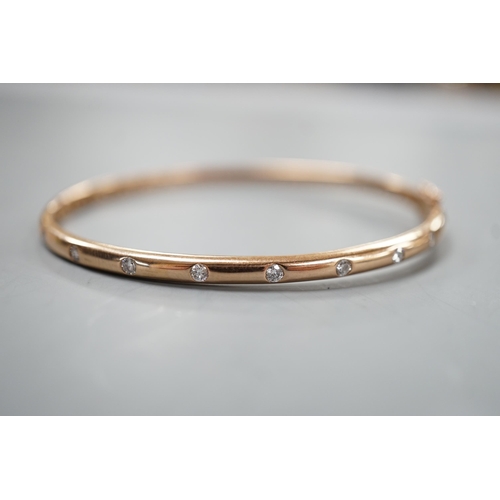 1940 - A modern 9k and nine stone gypsy set diamond hinged bangle, interior diameter 60mm, gross weight 9.3... 