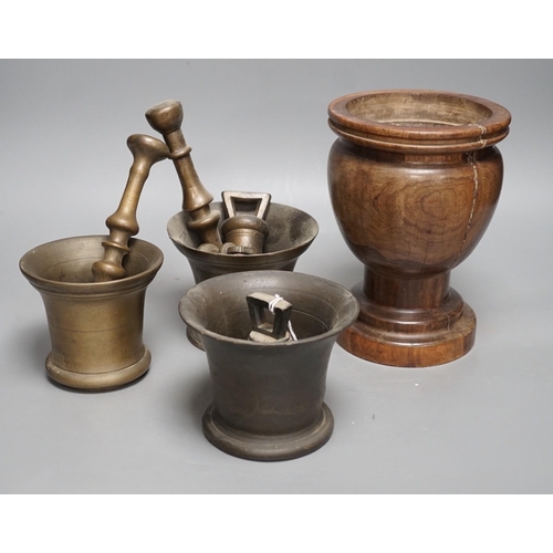 1385 - Three bell metal mortars, two pestles, a turned lignum vitae mortar and three postal weights, urn he... 