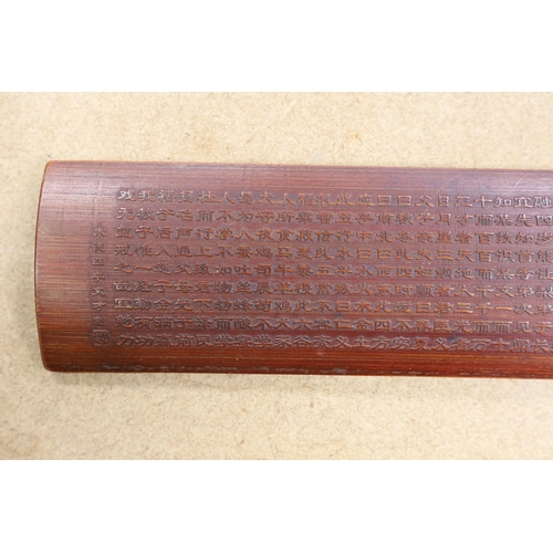 1599 - A Chinese bamboo inscribed wrist rest, carved in relief with columns of calligraphy, 30cm wide... 