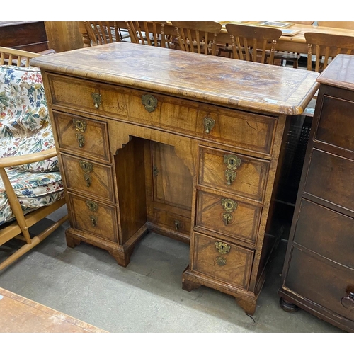 24 - A George II feather banded walnut kneehole desk, length 99cm, depth 57cm, height 88cm