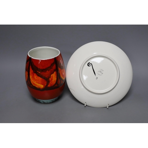 252 - A Poole pottery orange and red abstract vase and plate, 20cm diameter