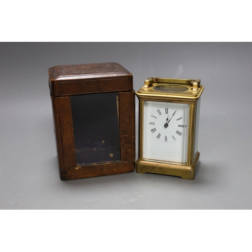 266 - A leather cased brass carriage timepiece. 13cm tall