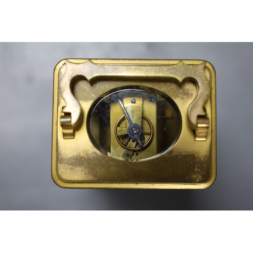 266 - A leather cased brass carriage timepiece. 13cm tall