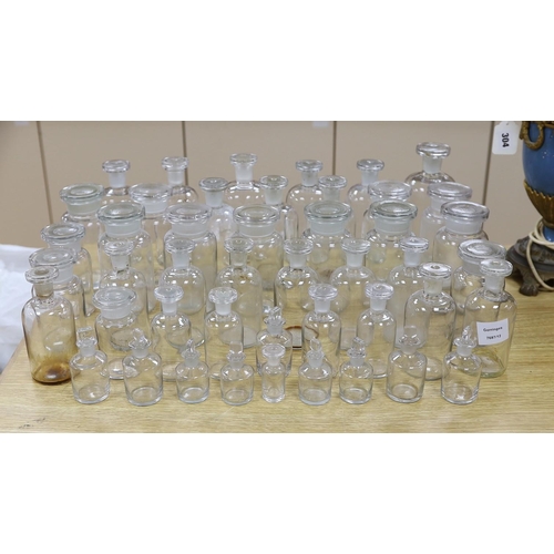 306 - A large collection of clear glass chemist's bottles