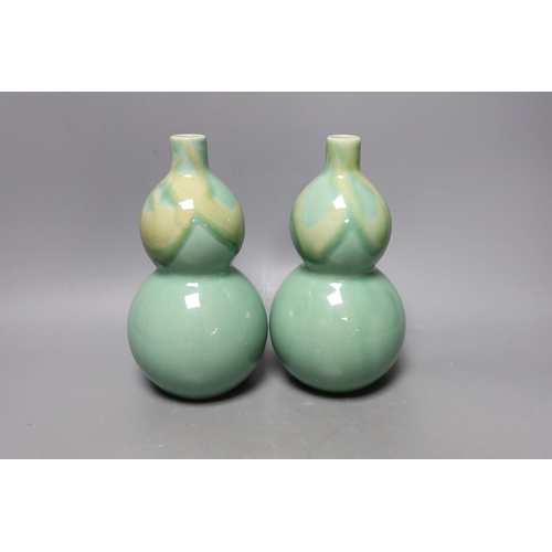 344 - A pair of Chinese celadon ground bottle vases 21cm tall