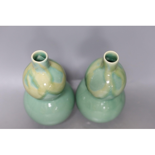 344 - A pair of Chinese celadon ground bottle vases 21cm tall