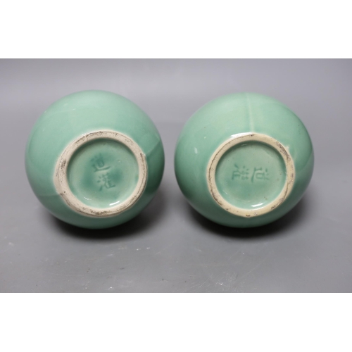 344 - A pair of Chinese celadon ground bottle vases 21cm tall