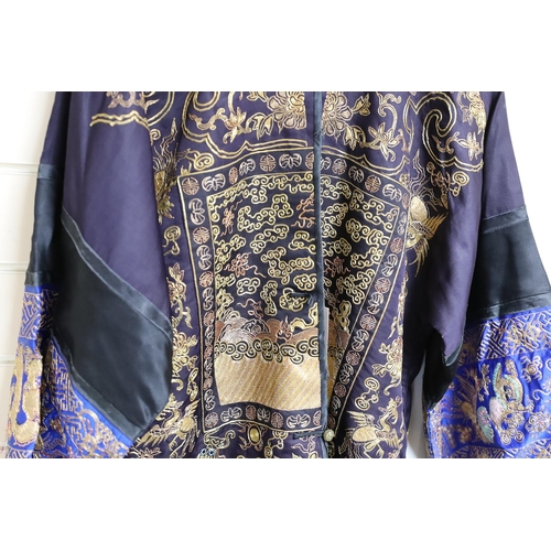 443 - A 20th century Chinese robe, decorated with navy ground and gilt thread all over five claw dragons... 