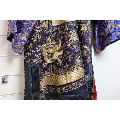 443 - A 20th century Chinese robe, decorated with navy ground and gilt thread all over five claw dragons... 