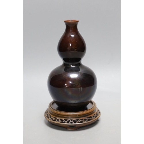 447 - A Chinese brown monochrome double gourd vase (on stand). 19cm tall